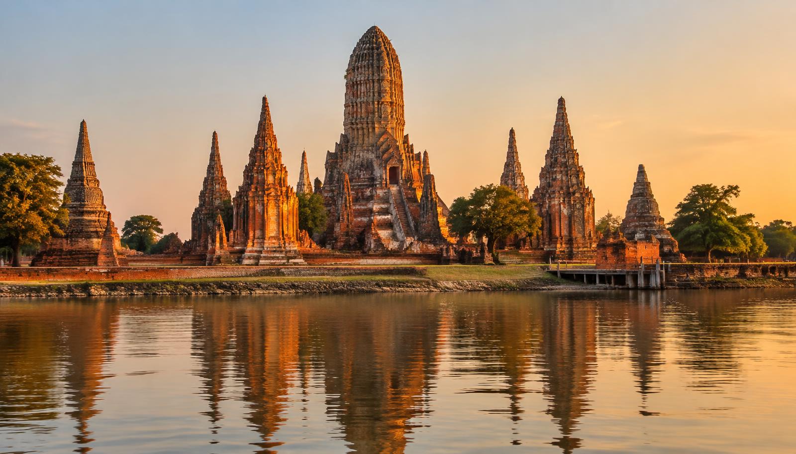 Brick prang and chedis of Wat Chaiwatthanaram beside the river in Ayutthaya, Thailand, at golden hour